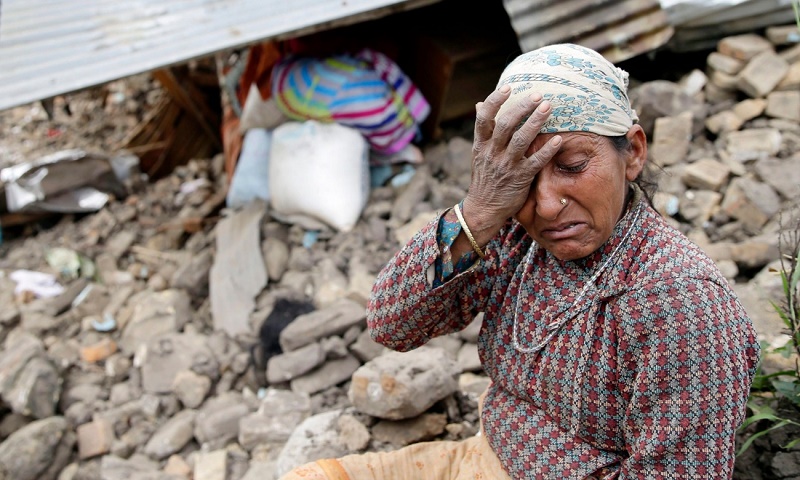 An elderly woman mourns in front of her destroyed home in the Kumalpur village, on the outskirts of capital Kathmandu.