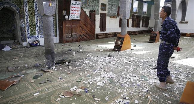 A policeman stands inside the al-Balili mosque after two suicide bombings at the mosque during Eid al-Adha prayers in Sanaa, Yemen, Thursday, Sept. 24, 2015. (AP Photo/Hani Mohammed)