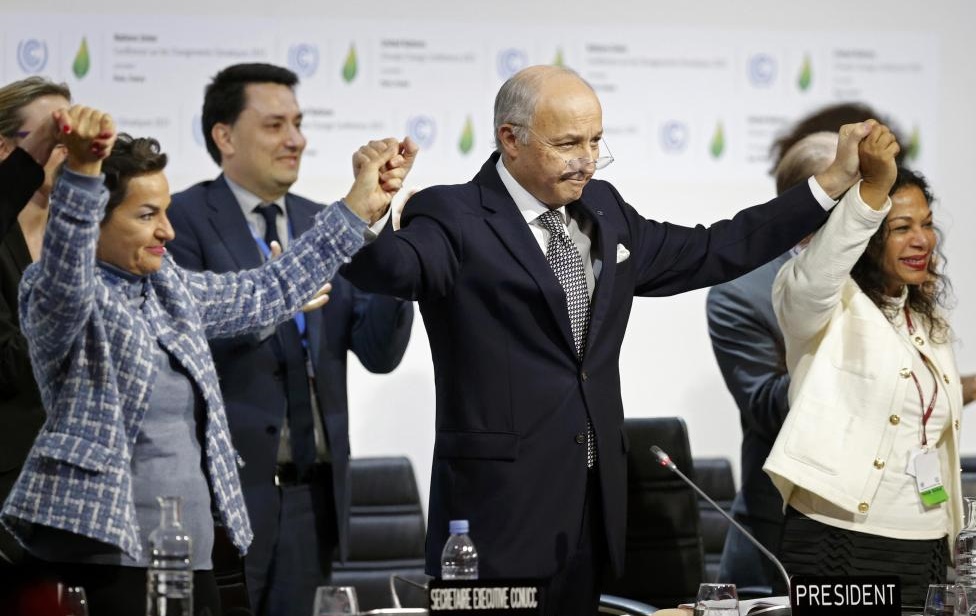 French Foreign Affairs Minister Laurent Fabius (C), President-designate of COP21 and Christiana Figueres (L), Executive Secretary of the UN Framework Convention on Climate Change, hold hands as they react during the final plenary session at the World Climate Change Conference 2015 (COP21) at Le Bourget, near Paris, France, December 12, 2015. REUTERS/Stephane Mahe