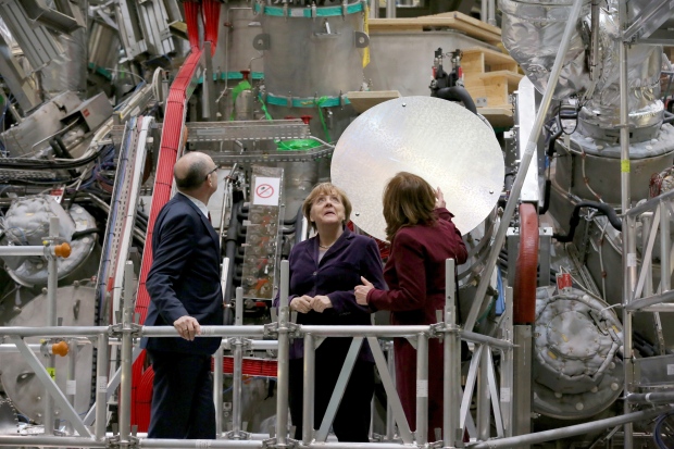 German Chancellor Angela Merkel, center, who holds a doctorate in physics, personally pressed the button at Wednesday's launch of an experiment they hope will advance the quest for nuclear fusion, considered a clean and safe form of nuclear power. AP Photo